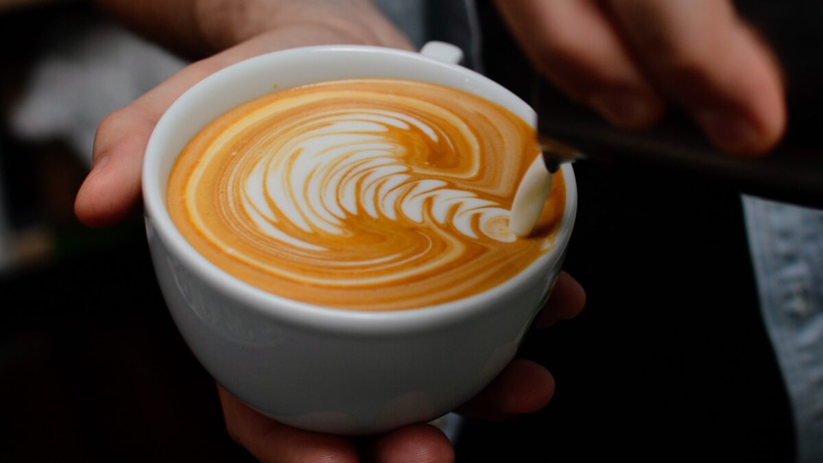 Image of latte art milk being poured into coffee